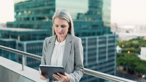 senior businesswoman working on tablet on rooftop