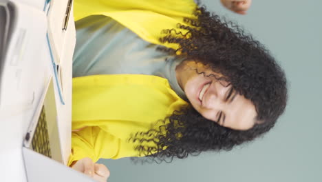 vertical video of young woman looks at laptop and rejoices.