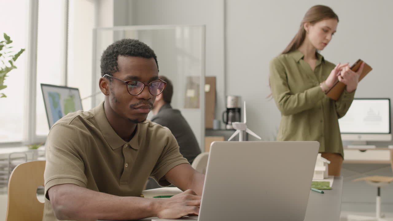 Man Using Laptop Sitting At Desk In The Office