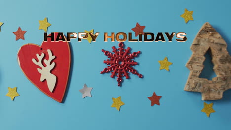 happy holidays text animation over christmas decorations on blue background