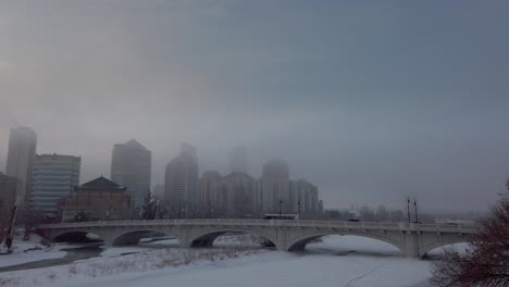 bus across river bridge in winter snow downtown calgary