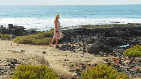 young woman with hat near rocky coastline of tenerife