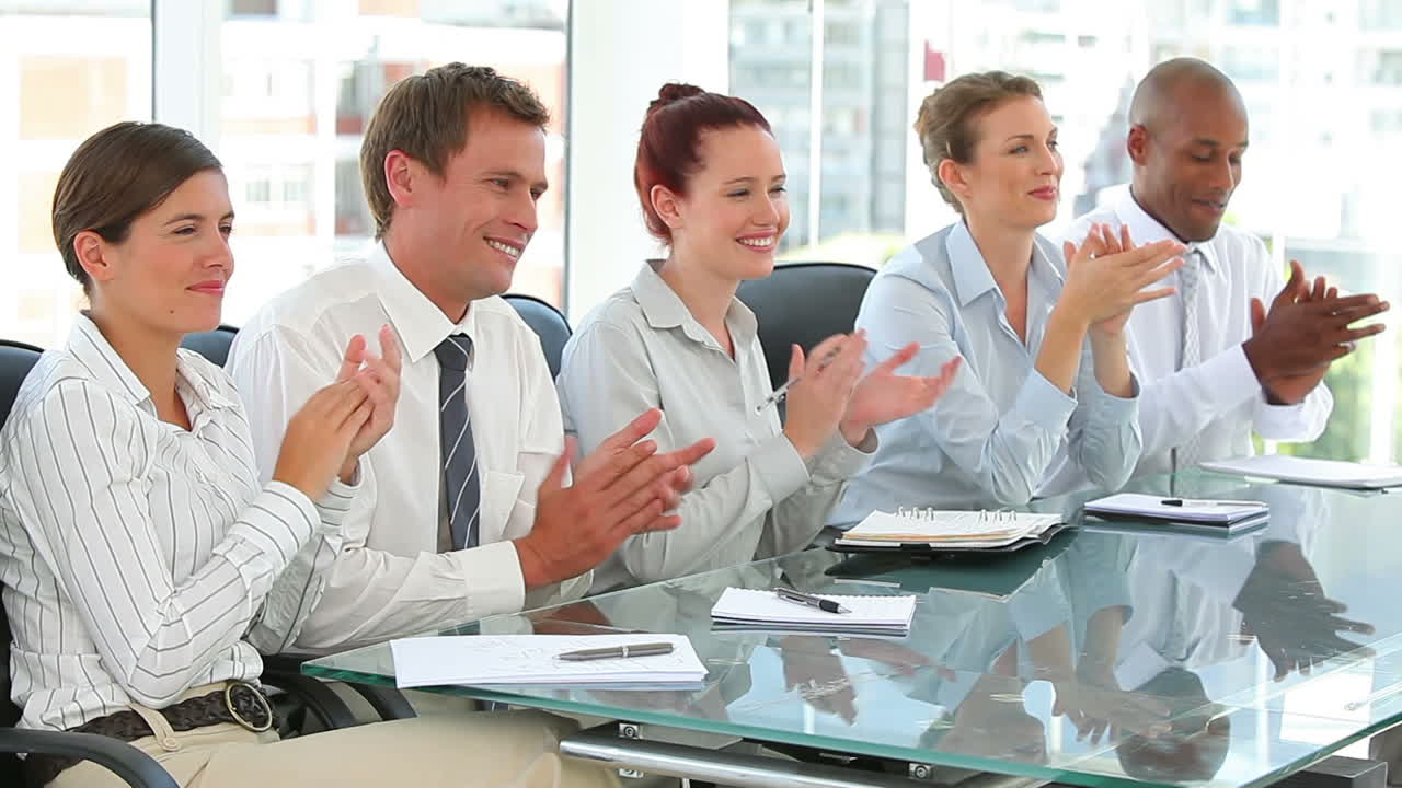 Clapping business team sitting together
