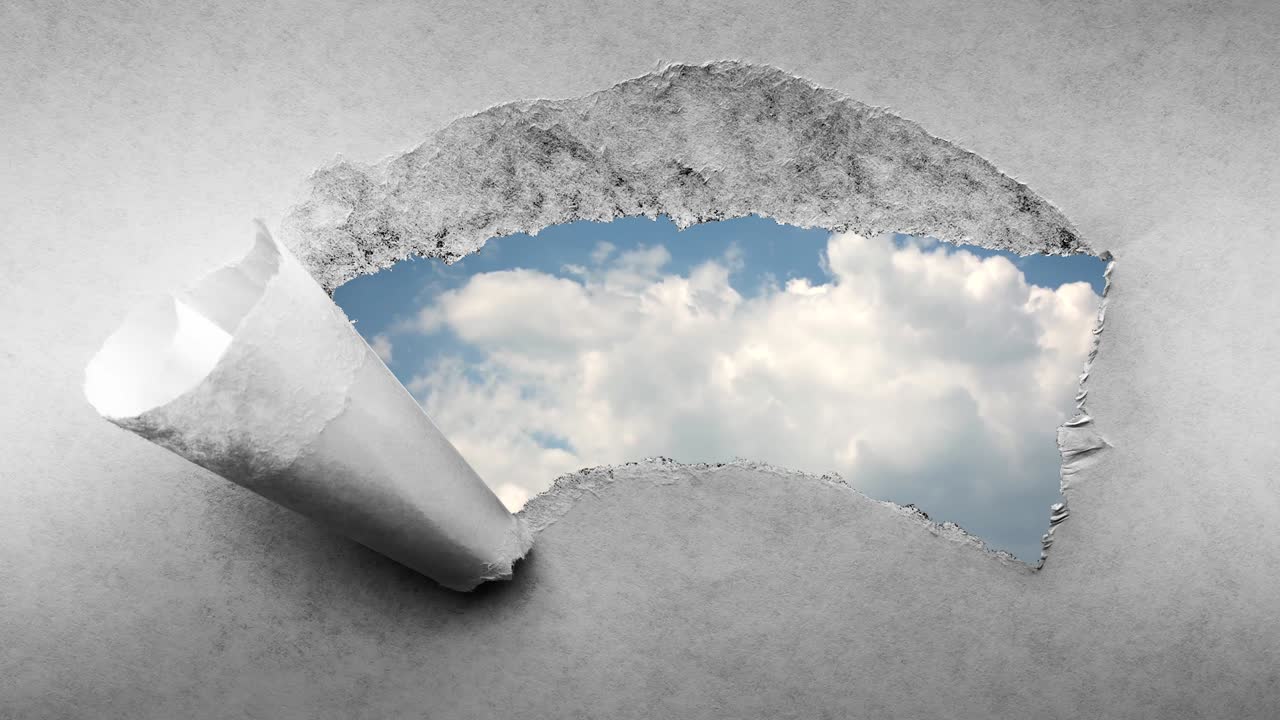 творческое 4k-видео быстро движущихся облаков в голубом небе, которые видны через отверстие с разорванными краями в старой ретро-гранж-винтажной бумаге.