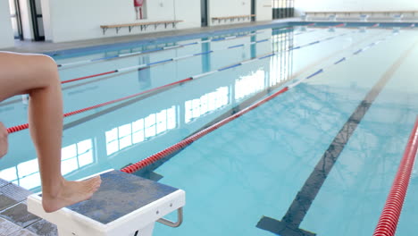 athlete prepares to dive into a swimming pool