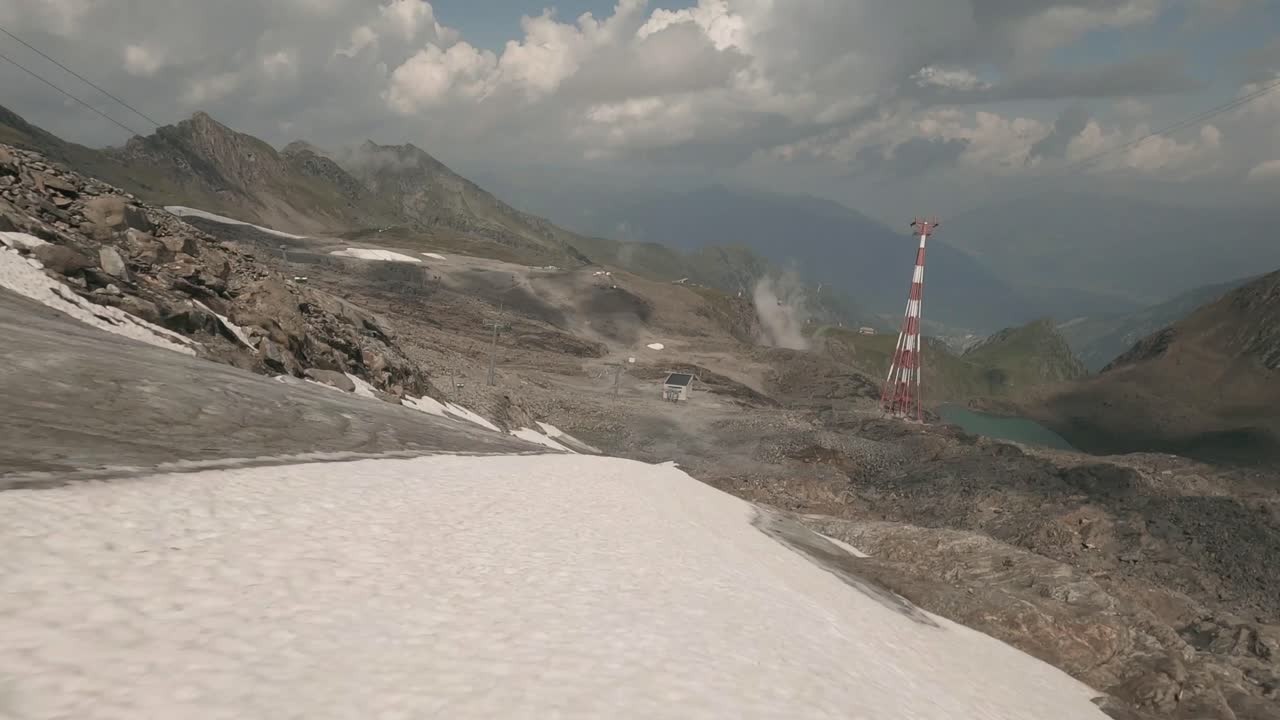 An FPV drone reveals Kaprun's Kitschteinhorn glacier during summer, offering a close look at the effects of global warming, with melting ice, snow, and rugged terrain exposed