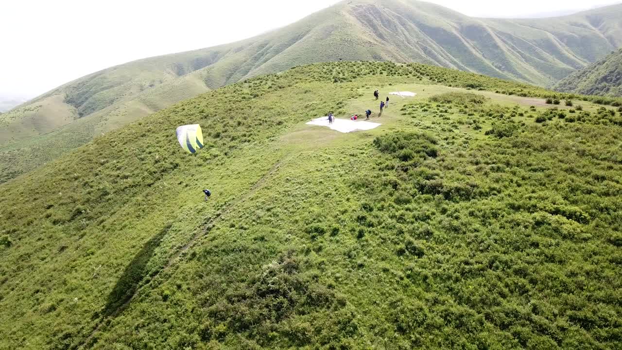 parapenteo en las montañas, campos verdes, colinas