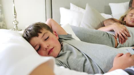 family sleeping together in bedroom 4k