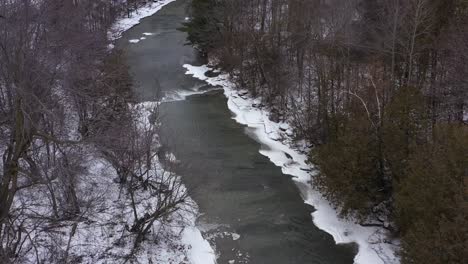 icy winter river between forests aerial high medium wide