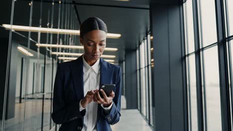 mujer de negocios que usa un teléfono inteligente en una oficina moderna