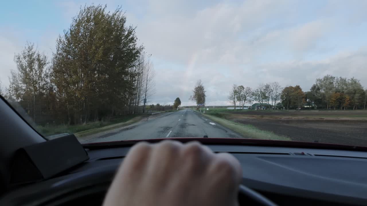 Gedeckte Farben, Landstraße mit Regenbogen in der Ferne und ruhige Spannung