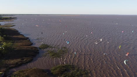 Vista-Aérea-Sobre-El-Río-De-La-Plata-Y-Todos-Los-Kitesurfistas-Al-Atardecer-En-Buenos-Aires-Argentina