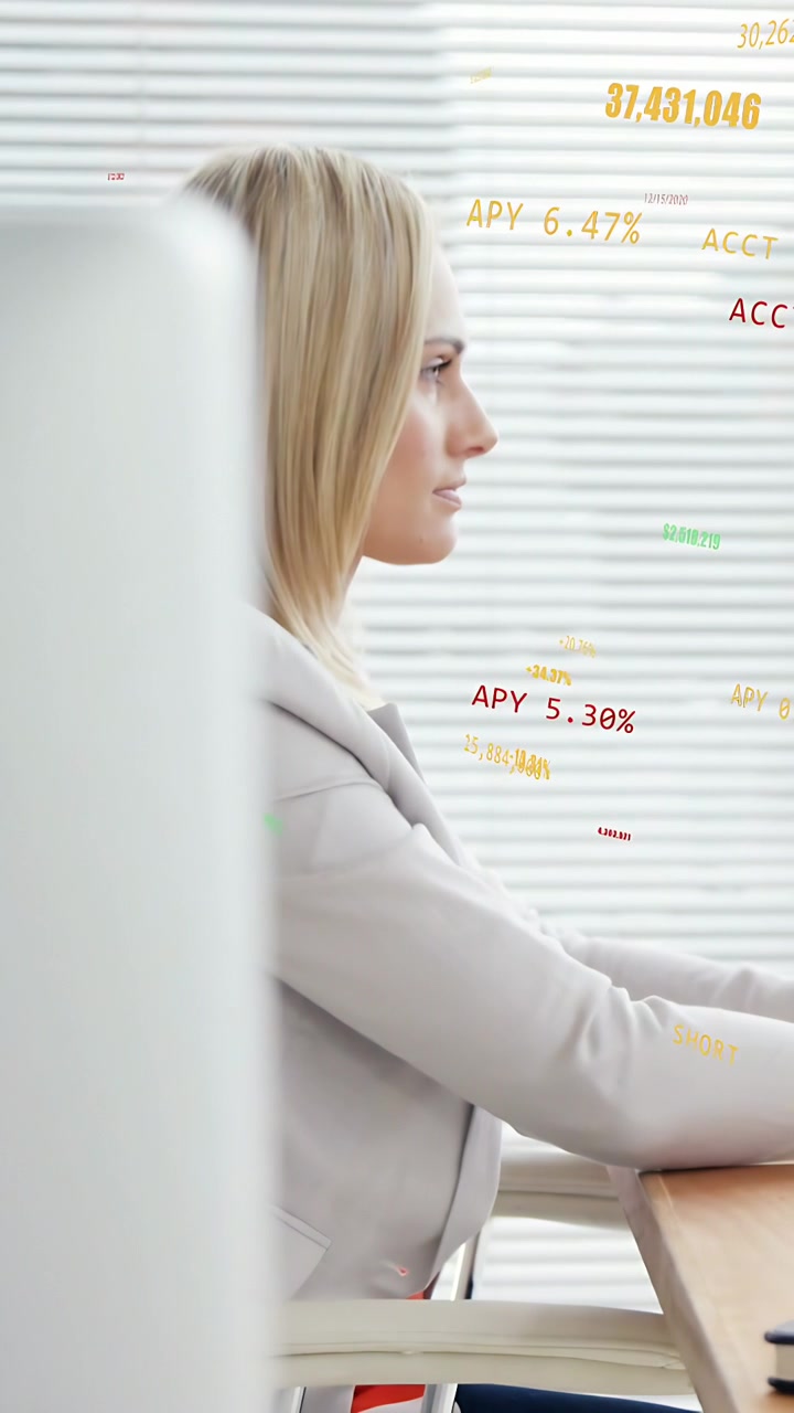 Video vertikal: Kamera menggeser memperlihatkan monitor, analis menggunakan mouse meninjau overlay keuangan.