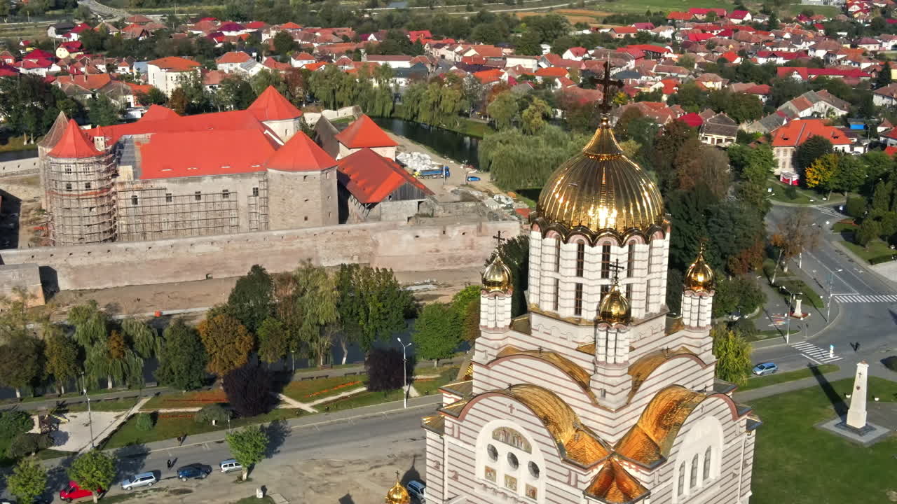 Aerial drone view of the Fagaras, Romania. Church of the Saint John the Baptist and Fagaras Citadel, buildings, roads with cars, greenery