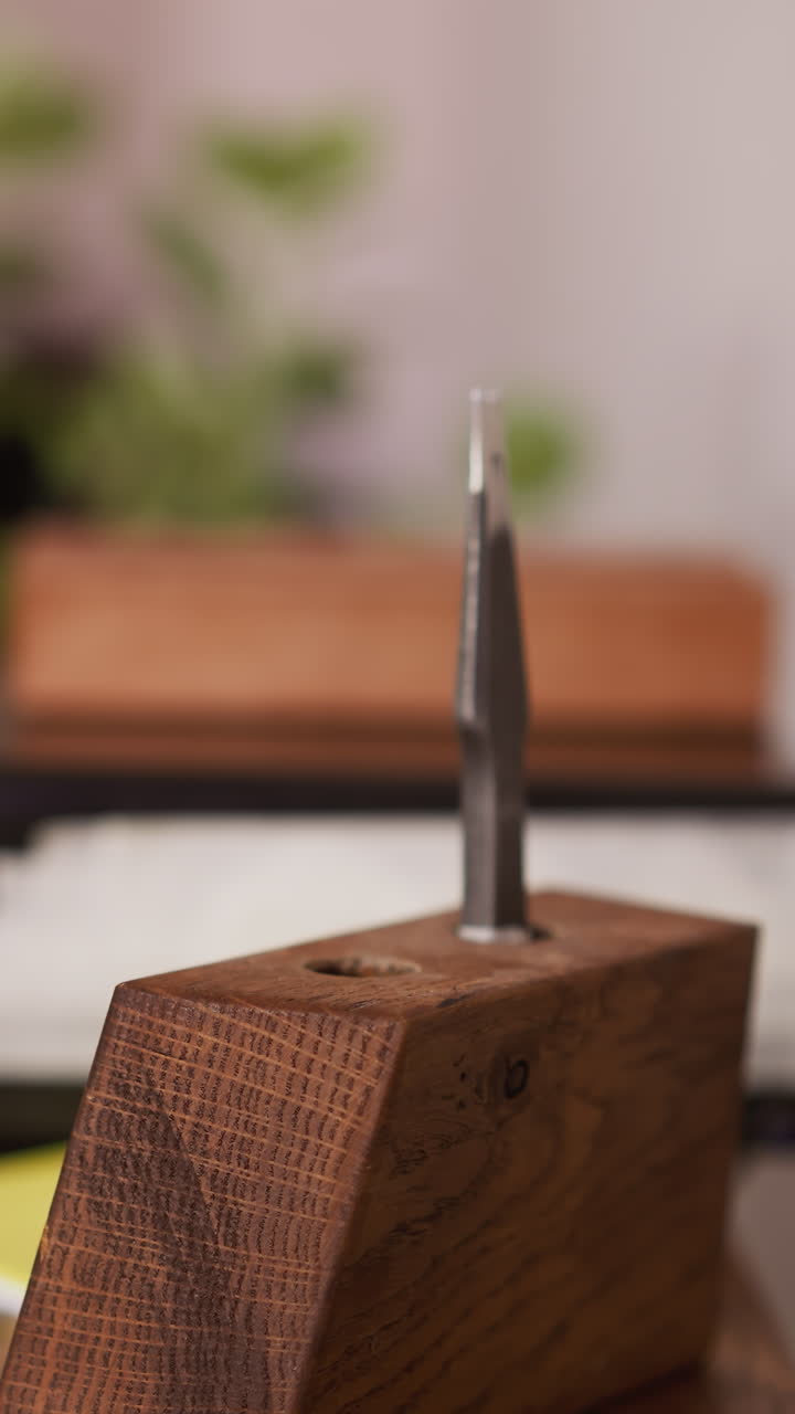 Worker takes leather cutter from wooden rack in craft workshop closeup. Manual instruments for material processing. Tool kit in manufacturing studio