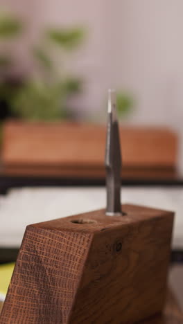 worker takes leather cutter from wooden rack in craft workshop closeup. manual instruments for material processing. tool kit in manufacturing studio