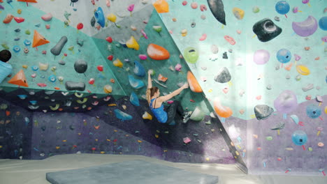 couple bouldering at indoor climbing gym