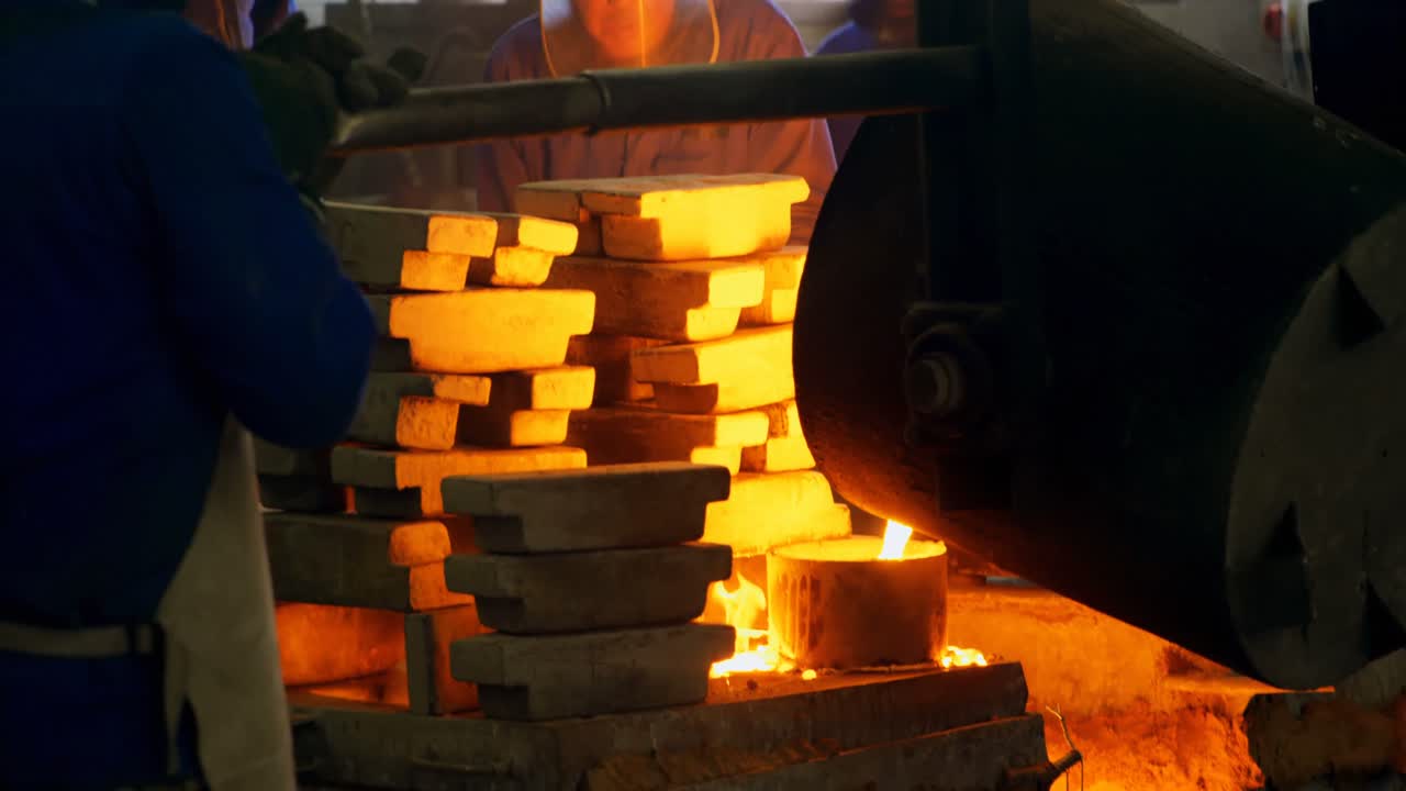 Male worker mixing molted metal in container at workshop 4k