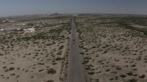 Drone-shot-of-a-mustang-driving-on-dirt-road