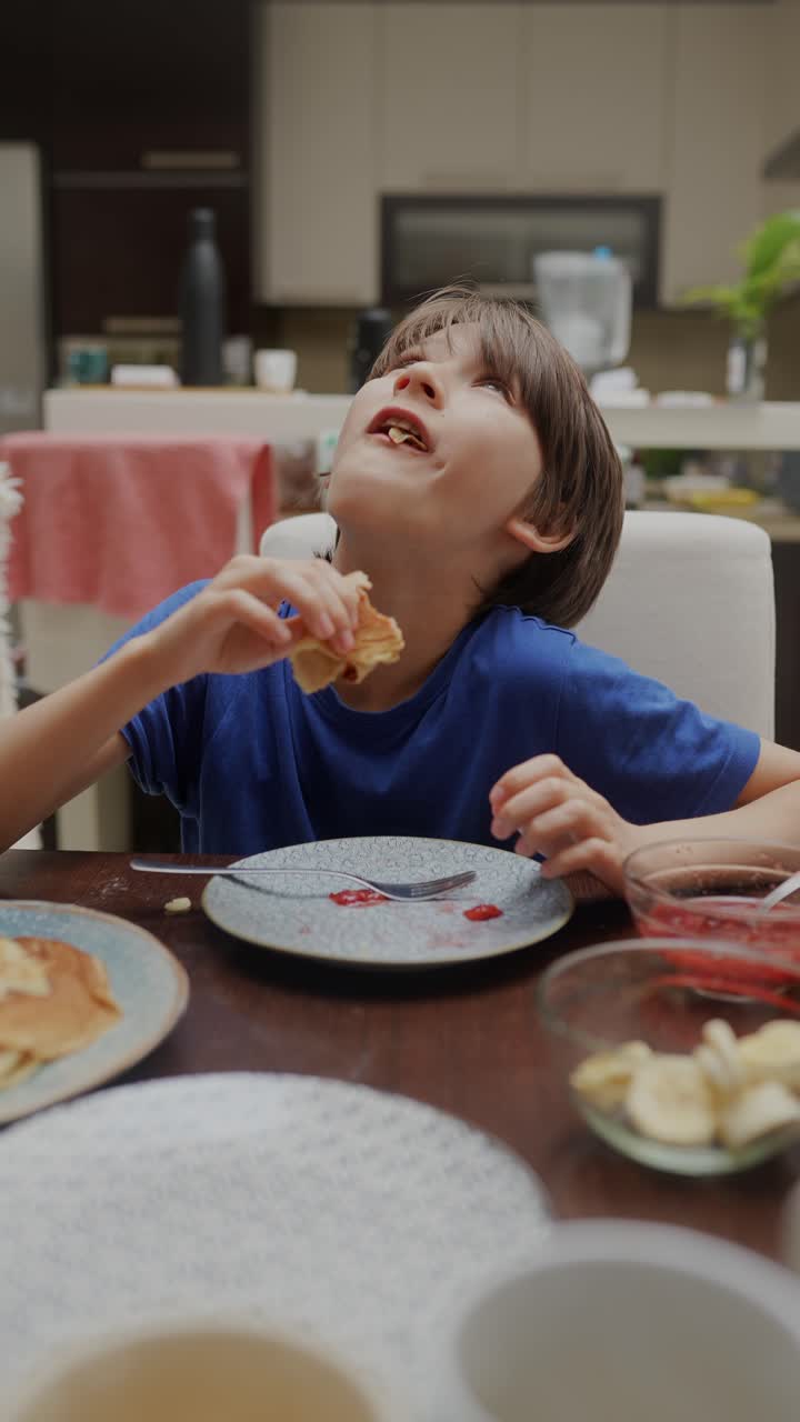 Boy Eating Pancakes at Breakfast Table