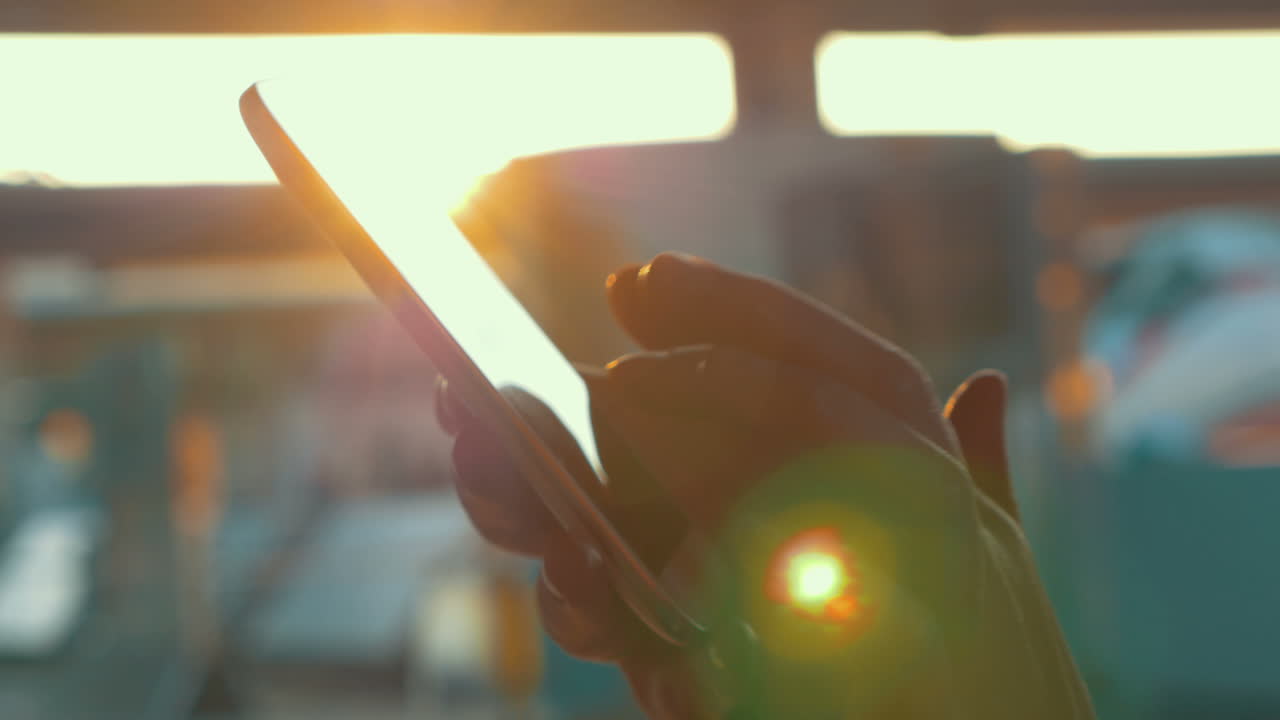 usando el teléfono inteligente contra la luz del sol brillante