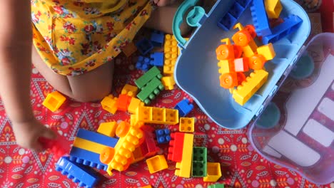 toddler playing with plastic building blocks