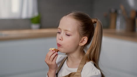 little girl enjoying a snack in the kitchen