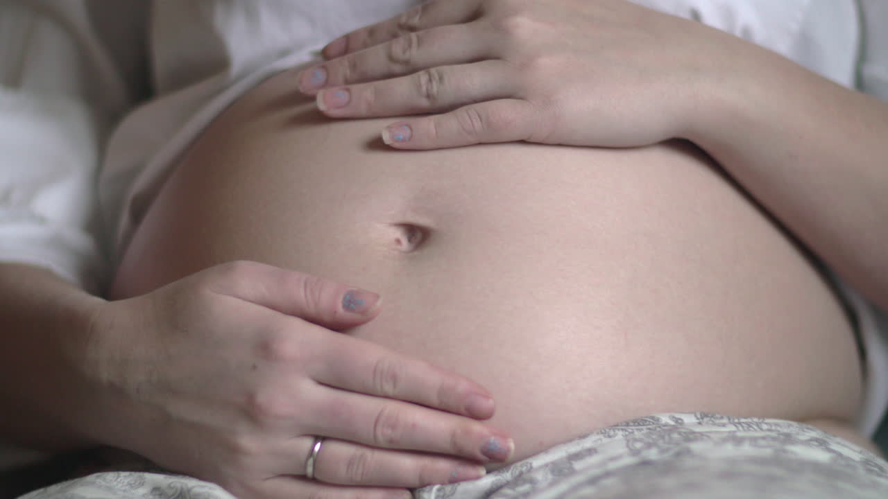 Donna incinta che tocca e accarezza la pancia