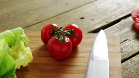 vegetables and kitchen knife on chopping board