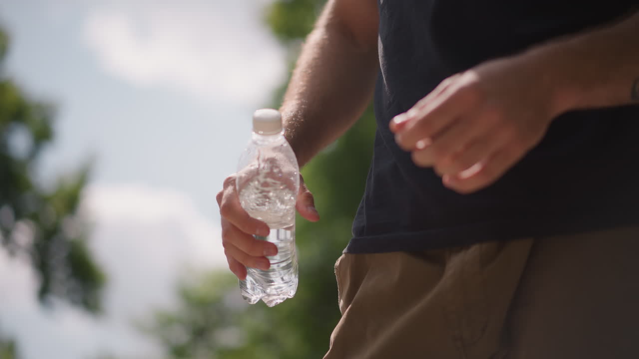 Skateboarder With Inked Forearm, Vivid Scene Of Skateboarder With Inked Forearm And Bright Surroundings, An Inked Arm Operating Water Bottle Amid Lively Skateboarder Scene Under Sunny Sky