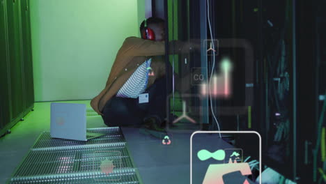 animación de iconos de ecología sobre trabajador masculino biracial en la sala de servidores