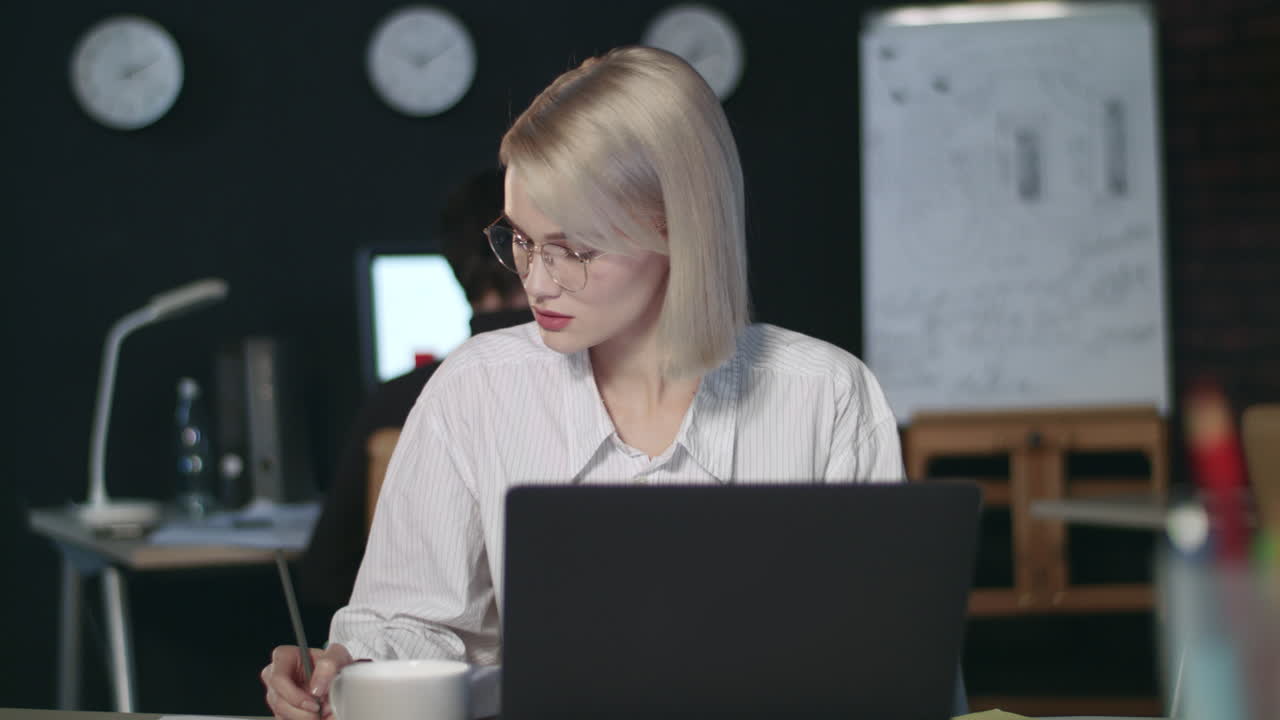 серьезная бизнес-женщина, работающая с финансовыми документами.