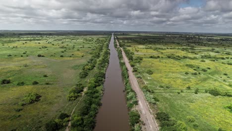 The drone glides smoothly over the riverbank, following the winding path of the river in Punta Lara, Buenos Aires.
