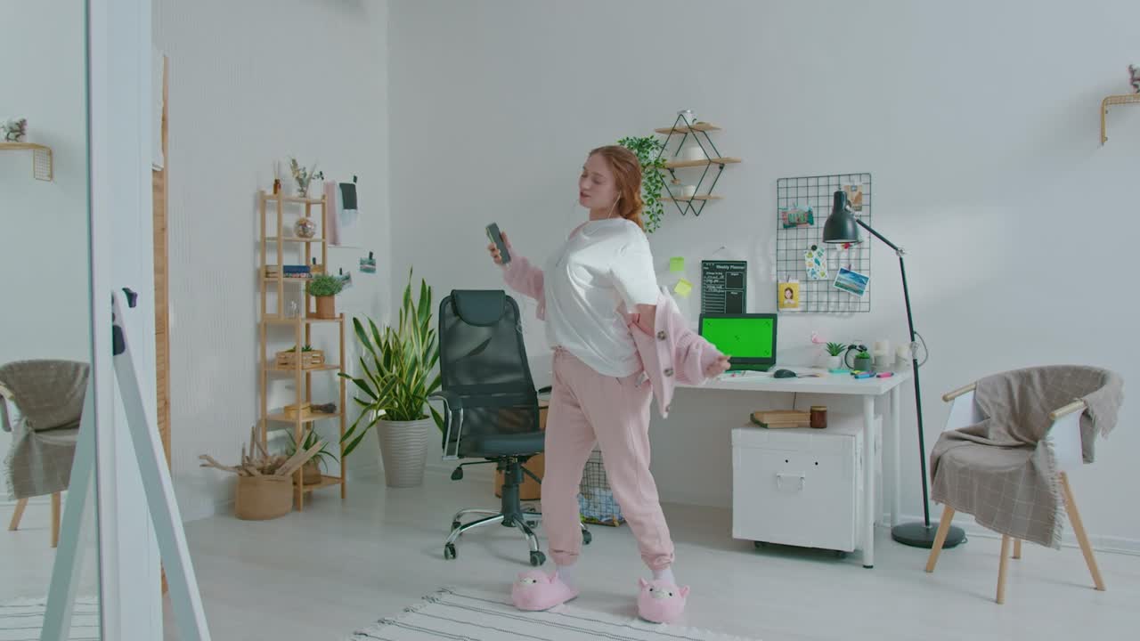 행복한 여성 디자이너가 음악을 들으면서 춤을 춘다