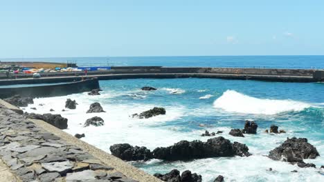 Vista-De-Las-Olas-Rompiendo-En-La-Costa-Y-El-Hermoso-Paseo-Costero-Vacío,-Panorámica-Hacia-La-Izquierda