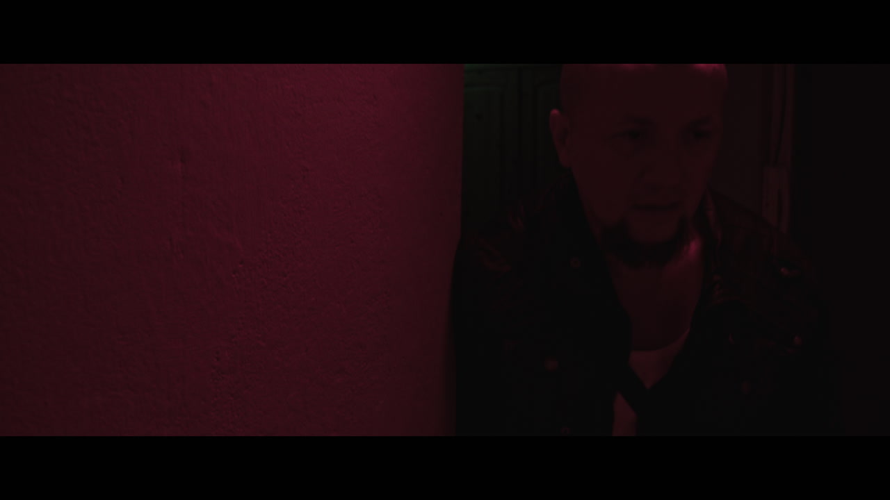 A bald gang member on guard