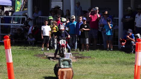 child motocross rider racing past spectators