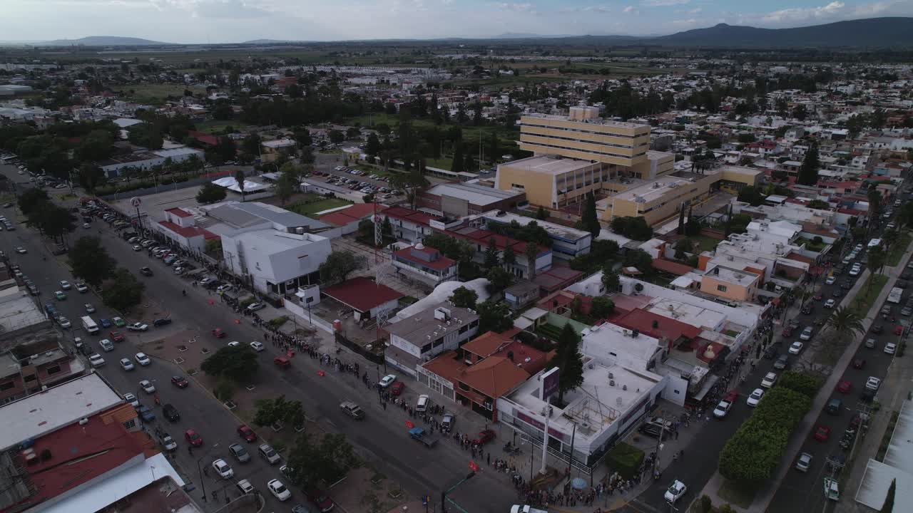Aerial view of a vibrant town with a long line of people along the street