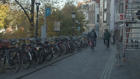 bicyclists cycling over street in the old center of utrecht, the netherlands