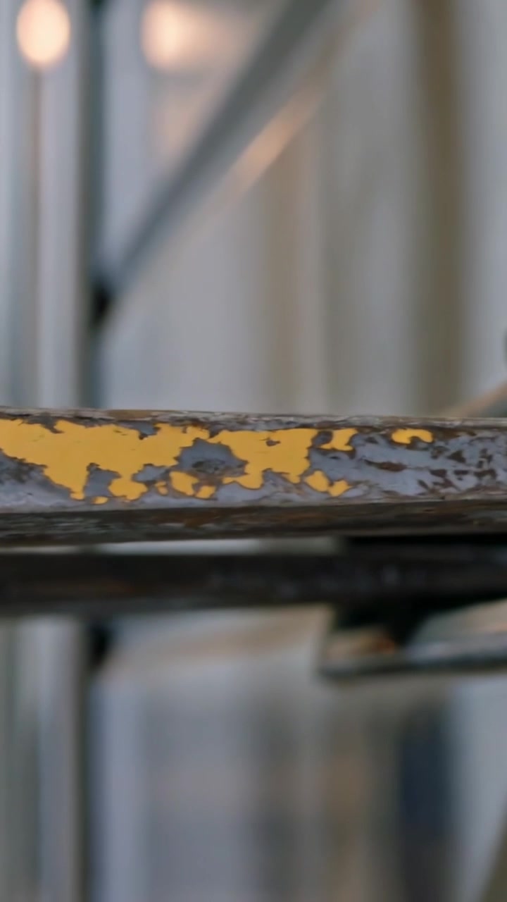 Vertical video: Pulling focus, panning camera revealing metal rail at studio, showing flaking paint