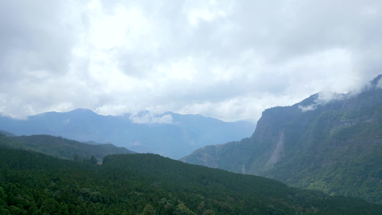 Misty Mountains Of Alishan With Dense Green Forests And Dramatic Cliffs. Chiayi County, Taiwan. wide drone shot, pullback