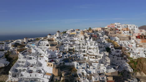 Drone-panning-shot-of-Oia-in-Santorini,-Greece-during-sunset,-4K-prores