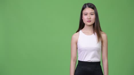 젊은 아름다운 아시아 사업가 여성이 엄지손가락을 올리고 있습니다.
