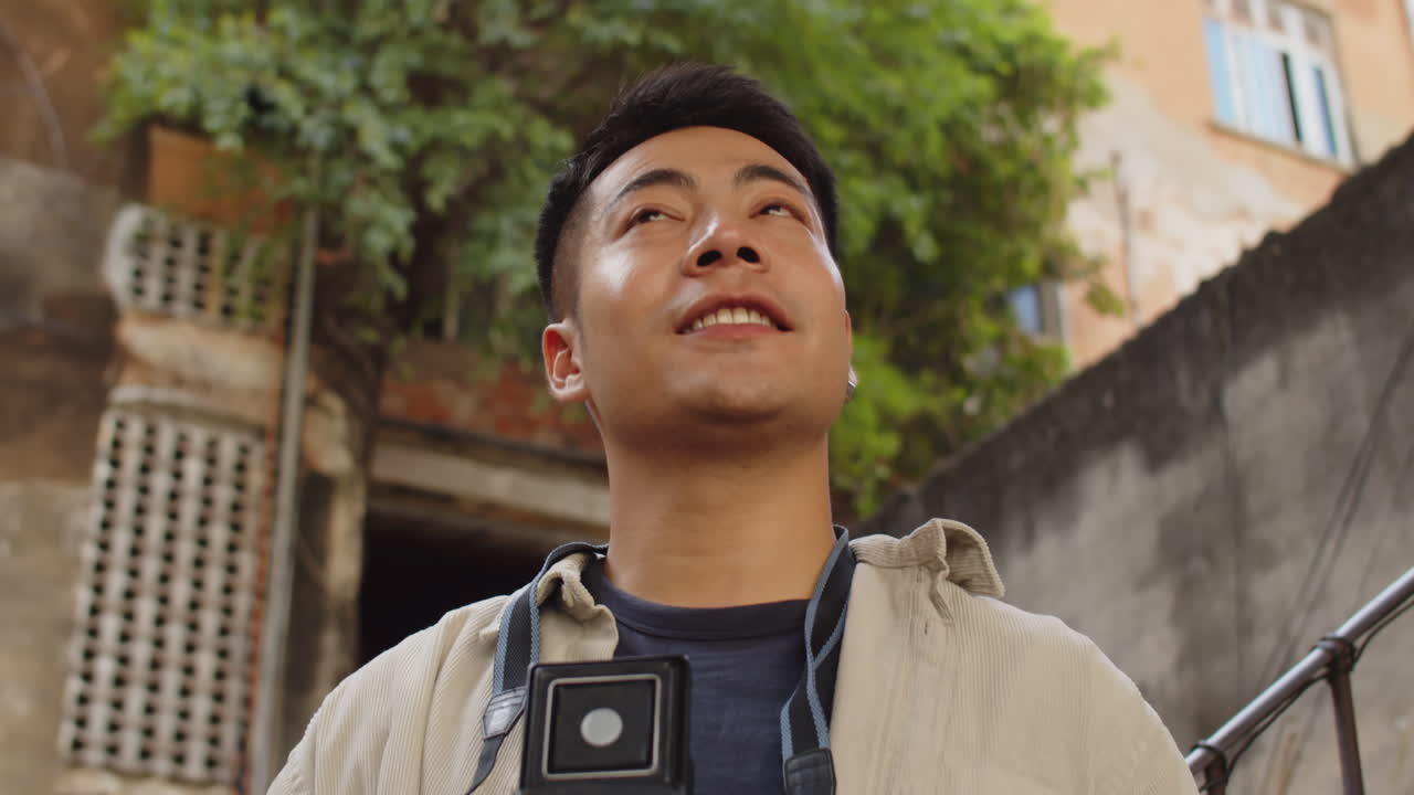 Positive Asian Man Capturing Exteriors of Old Buildings in Photograph