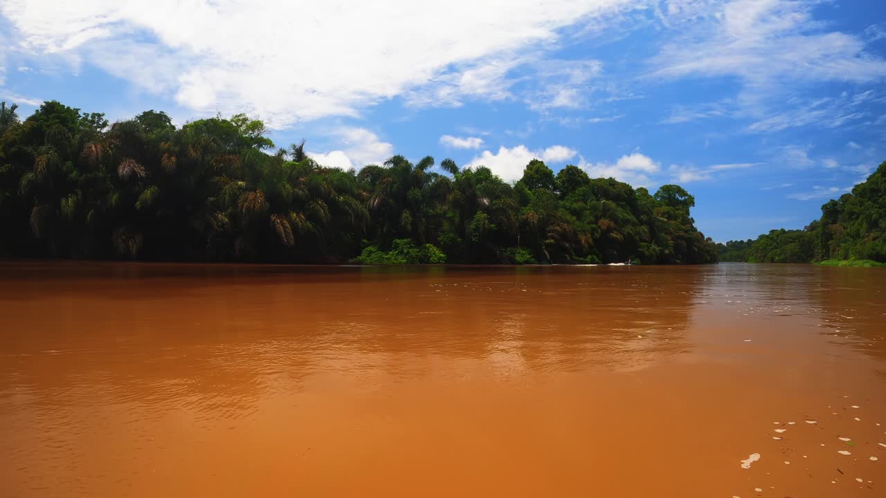 Local motorboat passes through the brown Tortuguero River close to the tropical coast in Costa Rica