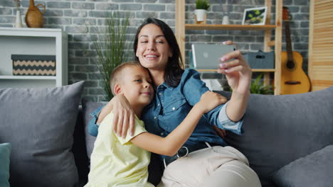 mother and son taking a selfie together on a sofa