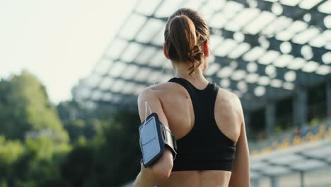 Die-Kamera-Bewegt-Sich-Von-Den-Füßen-Zum-Kopf,-Um-Eine-Junge-Joggerin-Zu-Fokussieren,-Die-Im-Stadion-Läuft