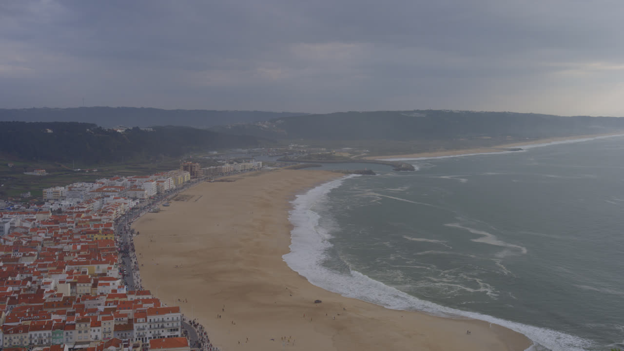pintoresca vista general de la costa de edificios históricos a lo largo de la playa en el pueblo pesquero costero de nazare, portugal