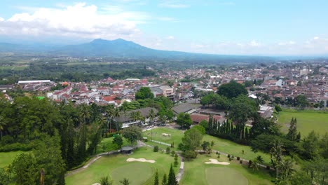 vista aérea de los atletas de golf están jugando al golf en el campo de golf en el medio de la ciudad