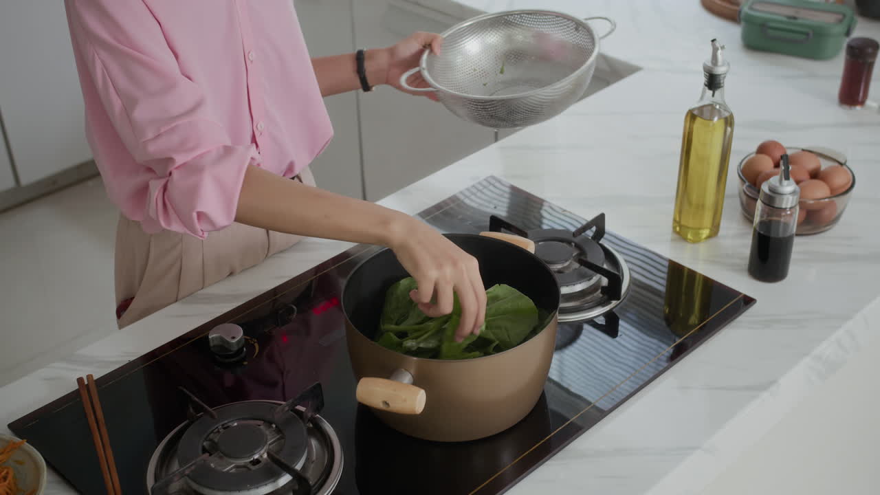 Anonymous Woman Boiling Green Leaves at Kitchen